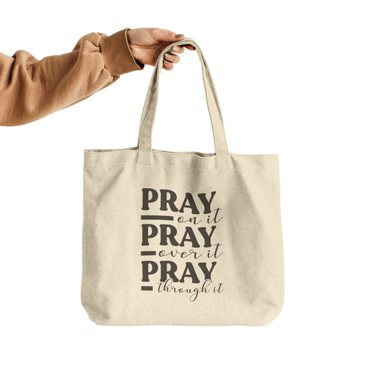 Pray_On_It_Pray_Over_It_Pray_Through_It__CottonTote_L_HandTransparent_Mockup.png